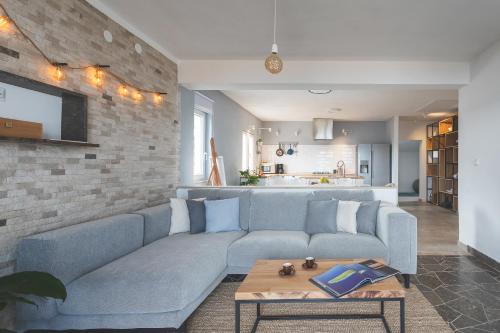 a living room with a blue couch and a brick wall at The Island Place in Bol