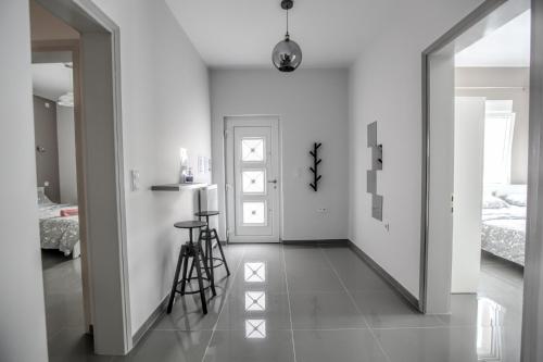 a white hallway with a white door and a bedroom at Terra di Meteora Suites #1 in Kalabaka