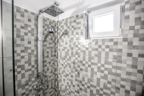 a bathroom with a shower with checkered tiles at Terra di Meteora Suites #1 in Kalabaka