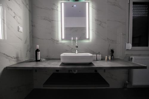 a white bathroom with a sink and a mirror at Terra di Meteora Suites #1 in Kalabaka