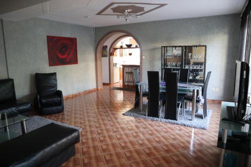 a dining room with a table and chairs in a room at Sobe-Apartmani Modriča in Modriča
