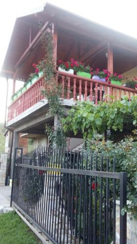 a house with a fence with flowers and plants at Prenoćište " Ruža" in Višegrad