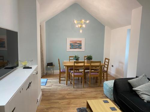 een eetkamer en een woonkamer met een tafel en stoelen bij Superb 2 beds 2 baths New Apartment w/ Garden+Patio in Bournemouth