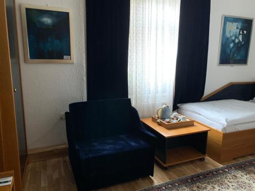 a bedroom with a bed and a chair and a table at Antik Hotel Sofia in Litomyšl