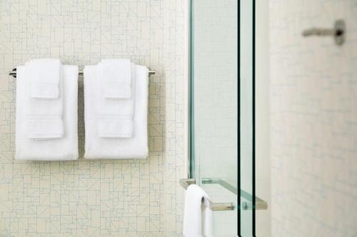 uma casa de banho com toalhas brancas penduradas numa parede em Holiday Inn Express & Suites Heath - Newark, an IHG Hotel em Heath