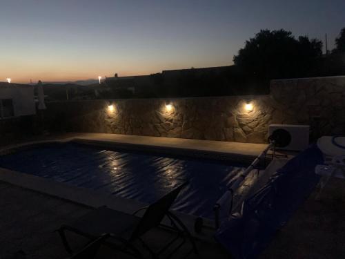 a swimming pool at night with chairs and lights at Casa Olivia villa in Arboleas