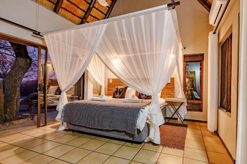 a bedroom with a bed with a canopy at 444 on Taaibos in Hoedspruit