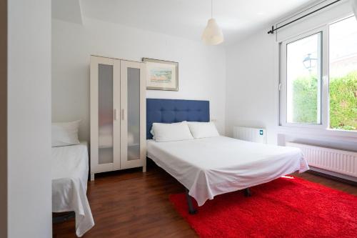 1 dormitorio con 2 camas y alfombra roja en Villa Auba Lloret, en Lloret de Mar