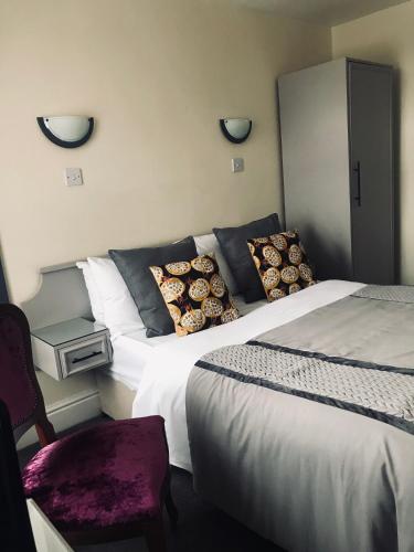 a hotel room with two beds and a chair at Lensfield Hotel in Cambridge
