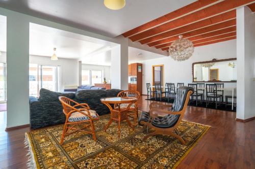 Una sala de estar con un sofá y sillas y una mesa. en Villa Auba Lloret, en Lloret de Mar