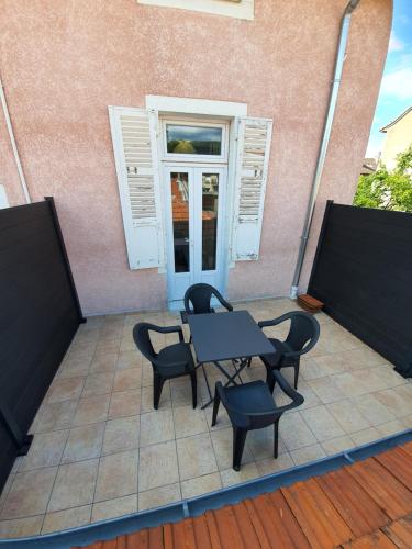 a table and chairs on a patio with a window at "Le Petit Paradis" au Centre Ville d'Oyonnax in Oyonnax