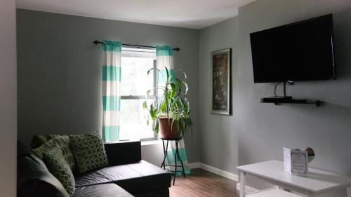ein Wohnzimmer mit einem Sofa und einem Fenster in der Unterkunft Sandy's Place NYC 1 in Brooklyn