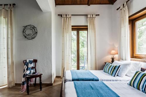 a bedroom with two beds and a window at Villa Driades in Skopelos Town