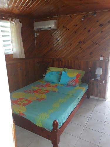 a bedroom with a bed in a wooden room at LE VILLAGE DE CANADA in Faup