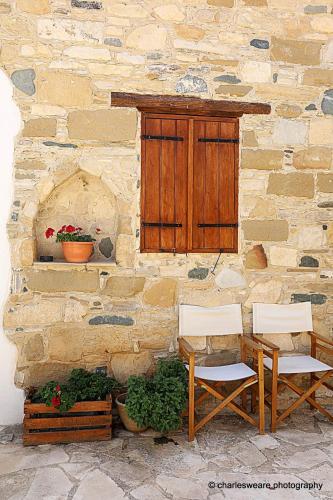 two chairs and a table in front of a stone building at Saint Antonio Maroni in Maroni