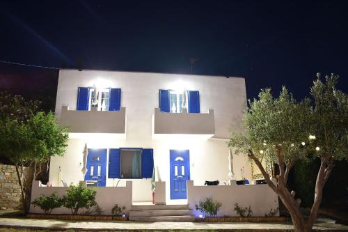 a white building with blue shutters on it at Litus Studios Syros in Megas Yialos-Nites