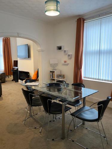 a dining room with a glass table and chairs at 39 Cowley Road in Liverpool