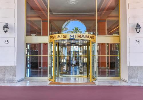 カンヌにあるPalais Miramar Imperial Croisetteの黄色い回転ドア付き建物の入口