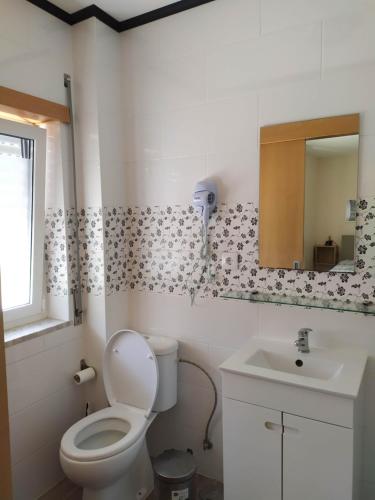 a bathroom with a toilet and a sink at Casa da Rota dos Moinhos in Lousã