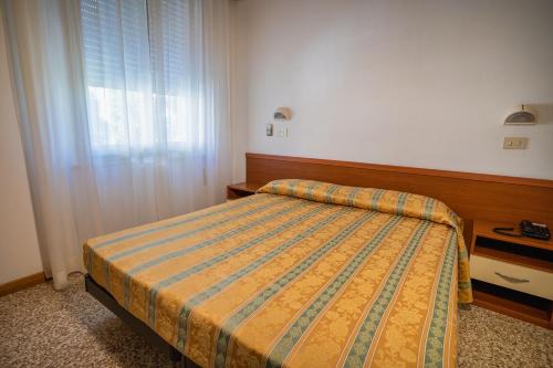 a bedroom with a bed and a window at Hotel Happy in Milano Marittima