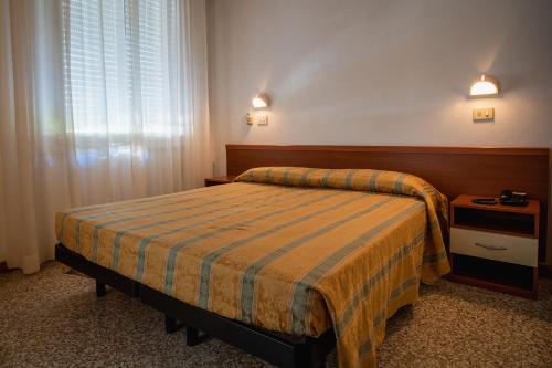 a hotel room with a bed and a window at Hotel Happy in Milano Marittima