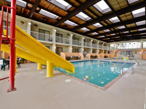 a swimming pool with a slide in a building at Ramada by Wyndham Plymouth Hotel & Conference Center in Plymouth