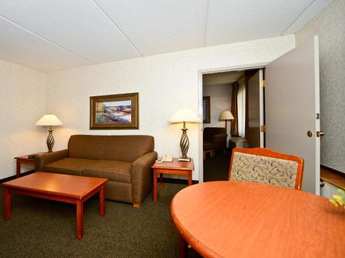 a living room with a couch and a table at Ramada by Wyndham Plymouth Hotel & Conference Center in Plymouth