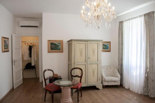 a living room with a table and a chandelier at Il Palazzetto in Sorrento