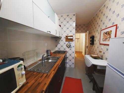 a small kitchen with a sink and a counter at Porta 7 in Canidelo