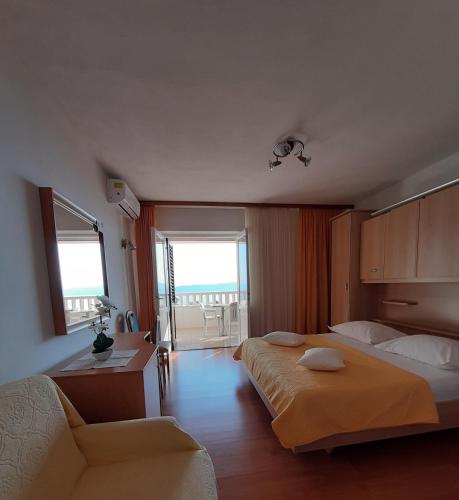 a bedroom with a bed and a desk and a couch at Guest house Fenix Brela in Brela