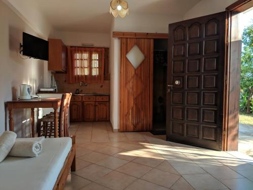 a kitchen with a large wooden door and a table at Oasis Apartments in Stoupa