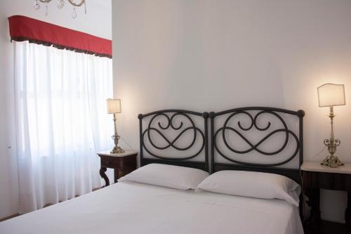 a bedroom with a white bed with a black headboard at Il Palazzetto in Sorrento