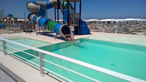 a person on a slide in a swimming pool at Hotel Villa Enea in Cattolica