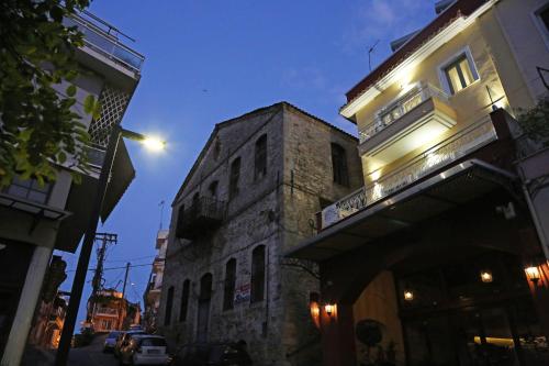 an old stone building with a balcony on a street at Under the Aqueduct boutique house in Kavala
