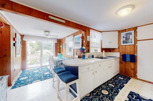 uma cozinha com armários brancos e um tapete azul em Paradise by Ocean Edge em Brewster