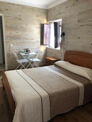 Un dormitorio con una cama y una mesa. en Casa do Canto en Vila Nova de Milfontes