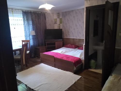 sypialnia z łóżkiem, stołem i oknem w obiekcie Willa Cosmos & Champion w Iławie