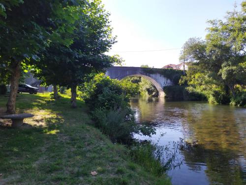 a bridge over a river with a bench next to it at Casa da Rota dos Moinhos in Lousã