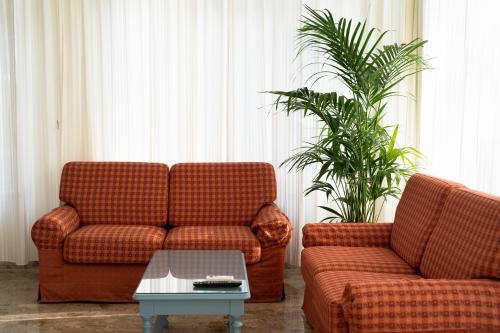a living room with two couches and a coffee table at Hotel Happy in Milano Marittima