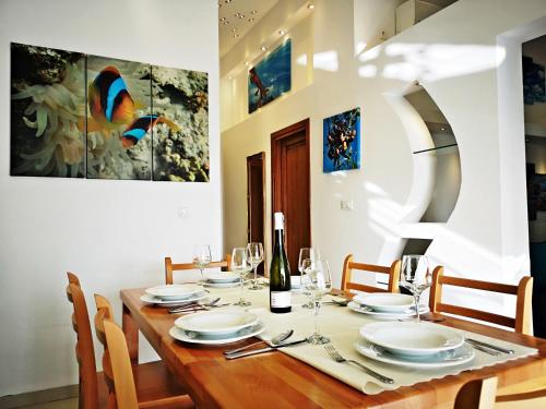 a dining room with a wooden table with a bottle of wine at Apartments Bo&scaron;ković in Stari Grad