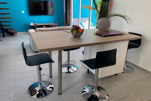 a table with chairs and a bowl of fruit on it at L'ylang ylang in Petit-Bourg
