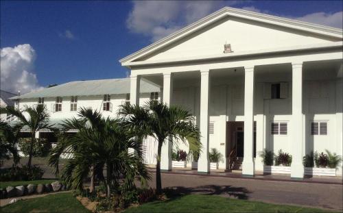 a white building with palm trees in front of it at The Liguanea Club in Kingston