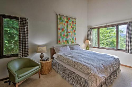 a bedroom with a bed and a green chair at Family-Friendly Glen Home with White Mountain Views! in Glen