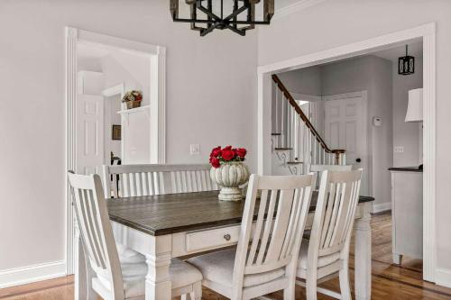 a dining room table with chairs and a vase of red flowers at Colonial Manor in Spring Hill