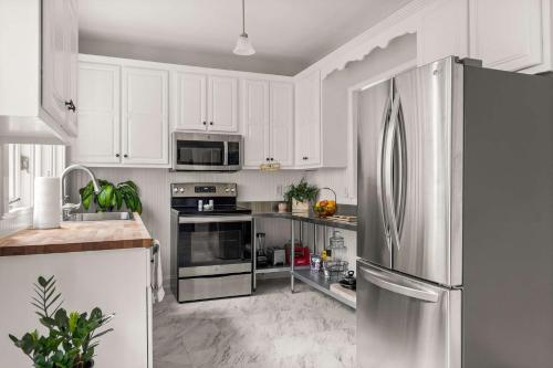 a kitchen with white cabinets and a stainless steel refrigerator at Colonial Manor in Spring Hill