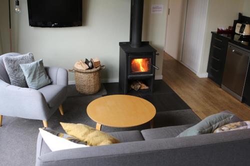 a living room with a fireplace and a couch at Lily Cottage - Lake Tekapo in Lake Tekapo