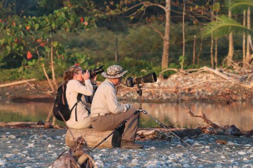 a woman taking a picture of a man with a camera at Four Monkeys Eco Lodge Jungle & Beach - The House in Cabo Matapalo