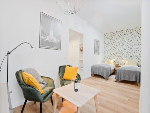 a living room with two chairs and a table at Best INN Poznań Apartament Orzeszkowej in Poznań