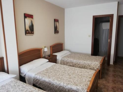 a hotel room with three beds in a room at Hospedaje Norte in Puentedeume