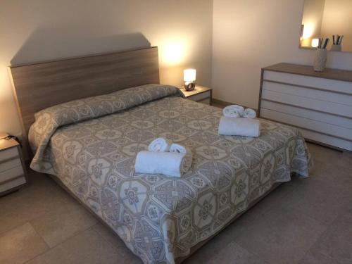 een slaapkamer met een bed met twee handdoeken erop bij Casa Giò in Cisternino